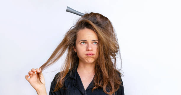 istock Sad woman combing styling tangled dry  weak hair on a white background. 1498462209
