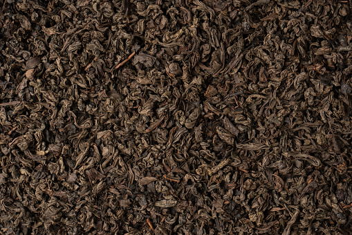 Dried tea leaves as a background. Top view.