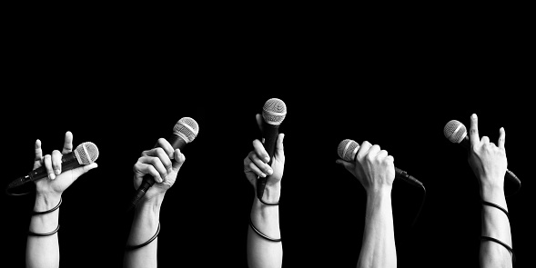 microphone in singer hand in various poses. black and white. singing and performer concept