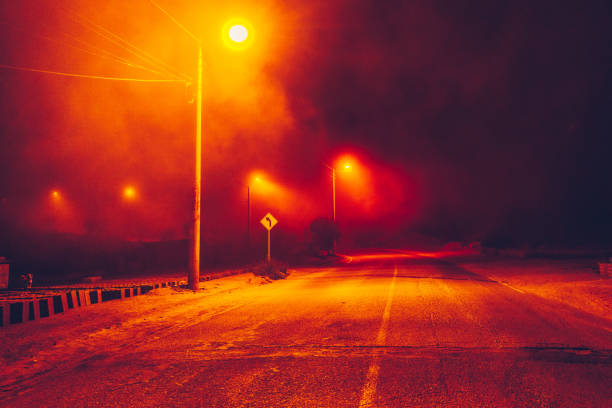 istock empty street at night with lights and traffic signals 1498465643