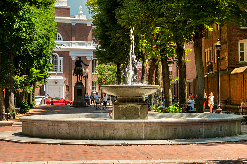 Boston, USA - July 19, 2022:  The George Robert Fountain and the Paul Revere statue on the historic Boston Freedom Trail with the Old North Church steeple in behind in Boston Massachusetts USA