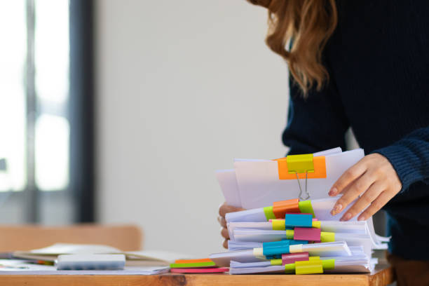 istock secretary searches through stacked documents on desk in office to find lease within stacked documents just before meeting. concept difficulty in finding hire purchase contract from stacked documents 1498465913