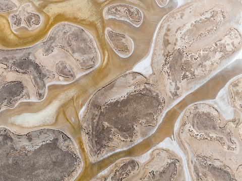 Aerial view of beautiful natural shapes and textures on a dried lake. Salt Lake (Tuz Gölü) located at the intersection of Ankara, Konya and Aksaray provinces in the Central Anatolian Region of Türkiye. Taken via drone.