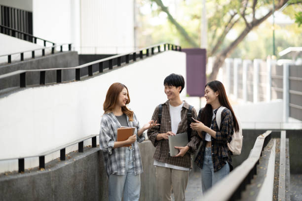 istock Group of happy students walking with notebook and laptop computer, walking into the classroom. 1498466181