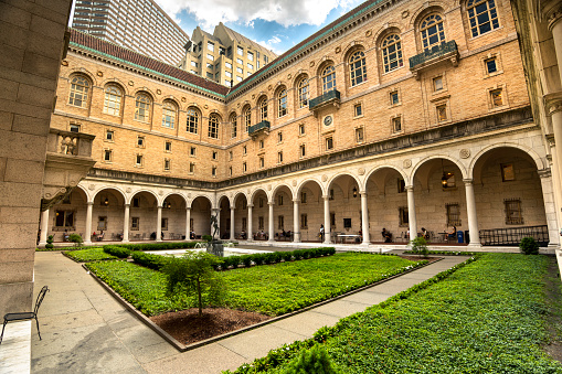 Boston, Massachusetts, USA – July 20, 2022:  Exterior white marble courtyard open plaza garden of the historic Renaissance style architecture of the Boston public library in the Back Bay District neighbourhood of downtown Boston Massachusetts USA