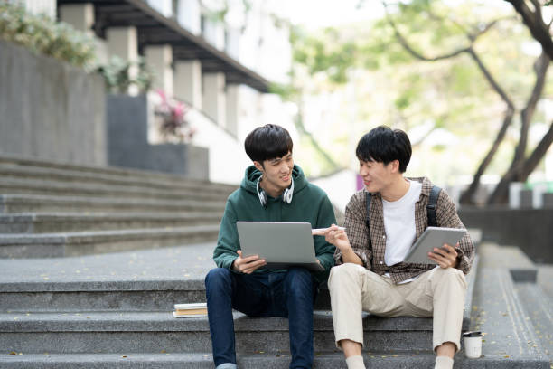 istock Young Asian college students reading books, studying on laptop while prepare for the exam. Education concept 1498467255