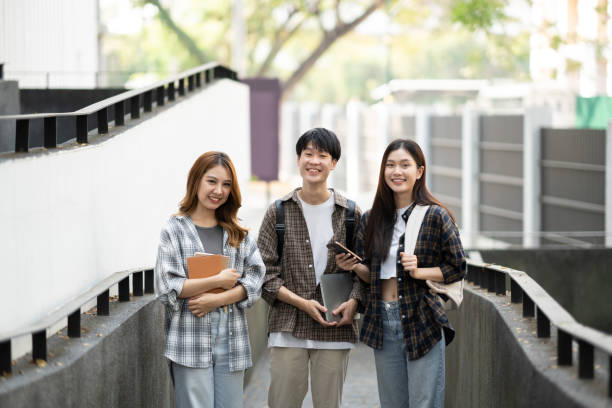 istock Group of happy students walking with notebook and laptop computer, walking into the classroom. 1498467946