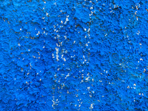 Full frame view of wall covered with stucco and painted with blue color