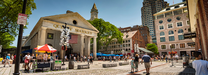 Boston, Massachusetts, USA – July 19, 2022:  People shop along the mall of the Quincy Market along the Freedom Trail across from the Great Hall of Faneuil Square in Boston Massachusetts USA