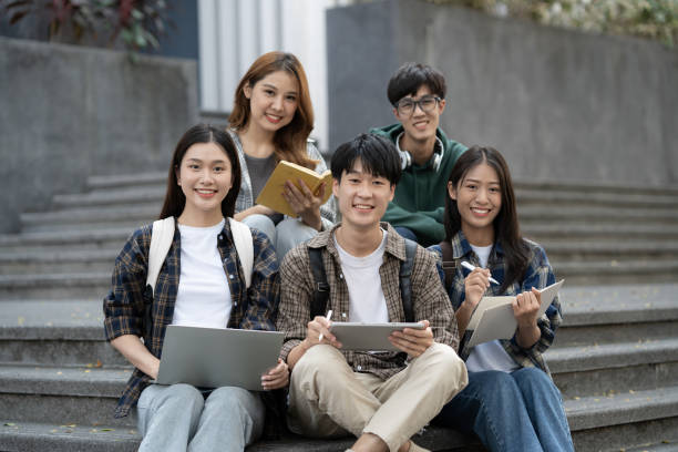 istock Potrait of young Asian college students working on group project while sitting on staircase of college campus. 1498470483