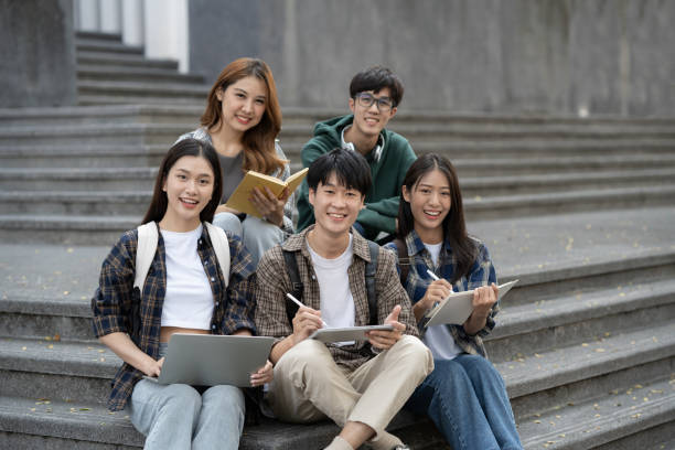 istock Potrait of young Asian college students working on group project while sitting on staircase of college campus. 1498471377