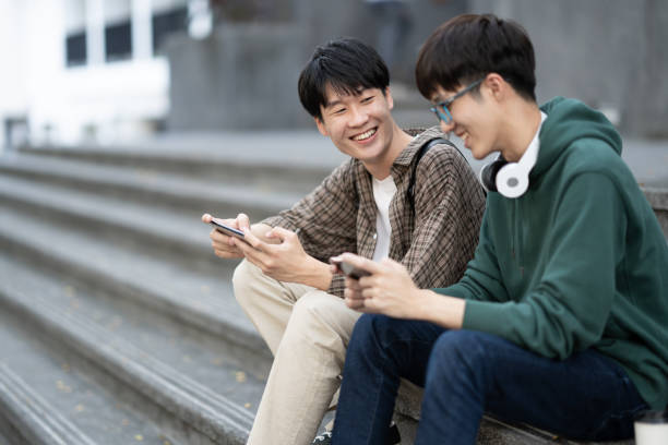 istock Cheerful college student spending time together in free time after the class, using smartphone and listening to music. 1498471796