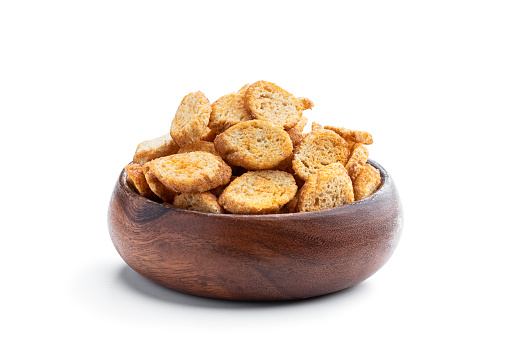 Crispy  croutons in wooden bowl isolated on white background