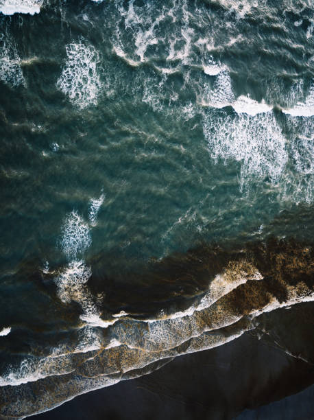 A drone point of view above the Pacific ocean waves in Long Beach, Washington state, USA.  Taken at summer sunset.