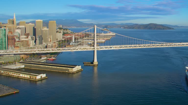Aerial view of the San Francisco Oakland Bay Bridge. California, USA. With traffic. Financial District in the background. Shot on Red weapon 8K.
