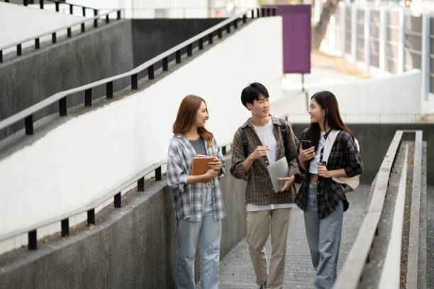 istock Group of happy students walking with notebook and laptop computer, walking into the classroom. 1498477525