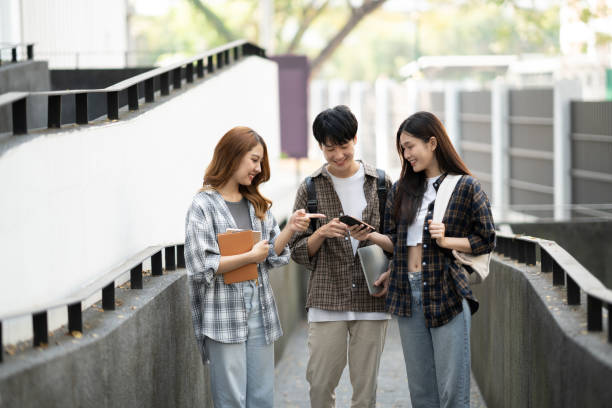 istock Group of happy students walking with notebook and laptop computer, walking into the classroom. 1498477723