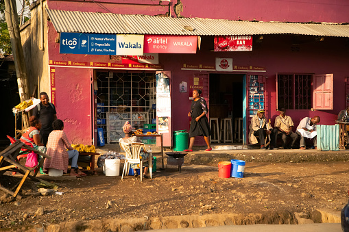 Mola,Kariba,Zimbabwe - December 08, 2018: Some African men and a woman  are sitting in the shade in front of a house  in Mola, a small village in the Kariba region of Zimbabwe.