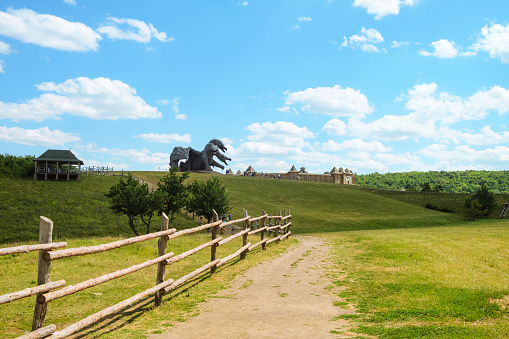 Lipetsk region, Russia - July 15, 2022: Kudykina Gora park. Fence of safari park. View on monument dragon Zmey Gorynych and wooden castle.