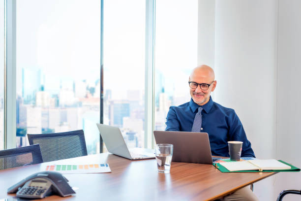 istock Mid aged business man using laptops and working in a modern office 1498486953
