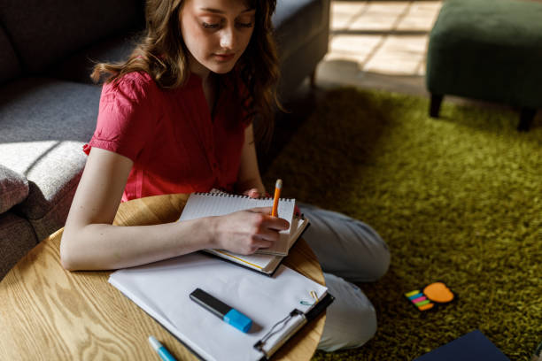 istock Young female university student studying and writing notes in notebook when preparing for exam 1498488240
