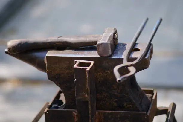 Hammer and tools for forging metal by a blacksmith. Blacksmithing in retro style outdoors