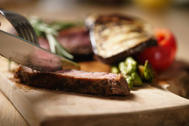 istock slicing medium rib eye steak with grilled vegetables 1498489884
