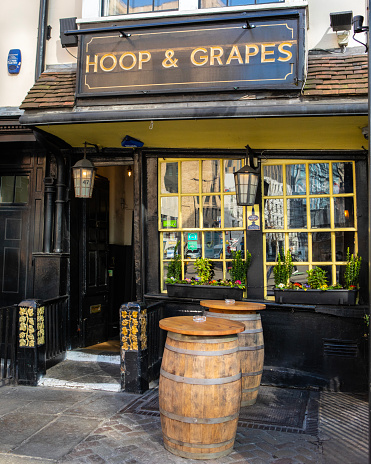 London, UK - March 2nd 2023: The historic Hoop and Grapes public house - a Grade II listed building on Aldgate High Street in the City of London, UK.