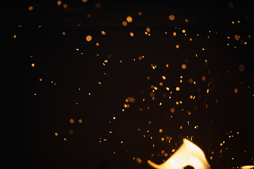 sparks from fire in fireplace with bokeh balls, shallow focus