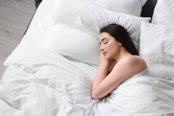 istock Beautiful young woman sleeping in soft bed, above view 1498500680