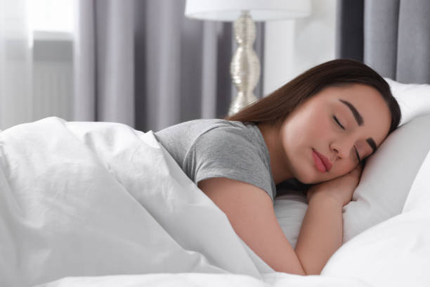 istock Beautiful young woman sleeping in soft bed at home 1498500857