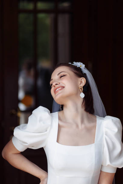 portrait of a beautiful bride in a white dress with a veil and a hoop of flowers. portrait of a beautiful bride in a white dress smiling with a veil and a hoop of flowers. hoops wedding stock pictures, royalty-free photos & images