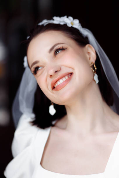 portrait of a beautiful bride in a white dress with a veil and a hoop of flowers. portrait of a beautiful bride in a white dress smiling with a veil and a hoop of flowers. hoops wedding stock pictures, royalty-free photos & images