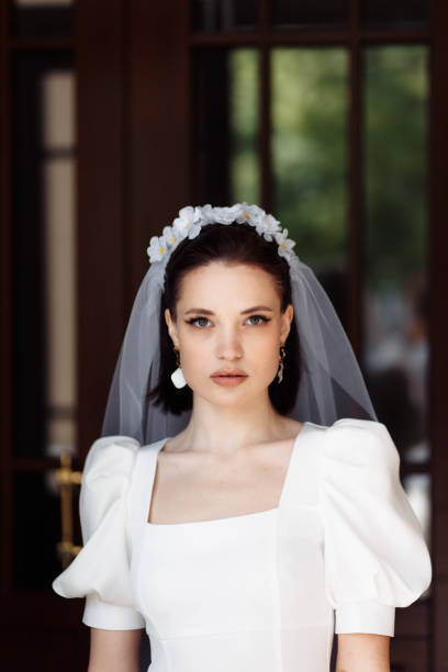 portrait of a beautiful bride in a white dress with a veil and a hoop of flowers. portrait of a beautiful bride in a white dress smiling with a veil and a hoop of flowers. hoops wedding stock pictures, royalty-free photos & images