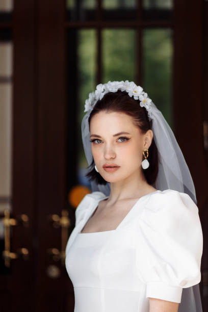 portrait of a beautiful bride in a white dress with a veil and a hoop of flowers. portrait of a beautiful bride in a white dress smiling with a veil and a hoop of flowers. hoops wedding stock pictures, royalty-free photos & images