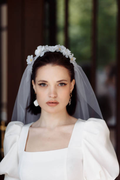 portrait of a beautiful bride in a white dress with a veil and a hoop of flowers. portrait of a beautiful bride in a white dress smiling with a veil and a hoop of flowers. hoops wedding stock pictures, royalty-free photos & images
