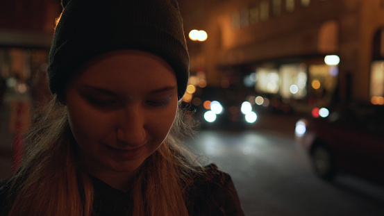 teen girl on street of Chinatown in San Francisco at night, wide photo
