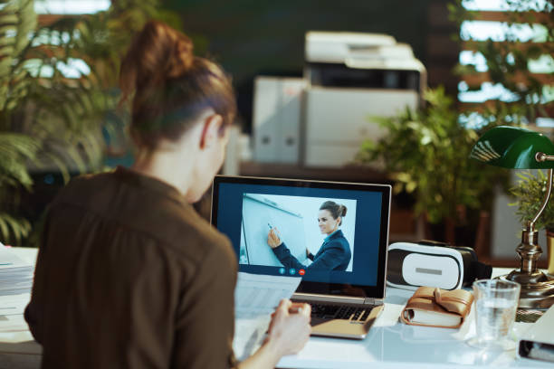 istock Seen from behind modern woman with documents having video chat 1498502659