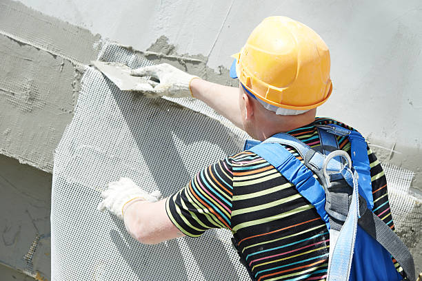 facade builder plasterer at work builder worker plastering facade of high-rise building with putty knife steeplejack stock pictures, royalty-free photos & images