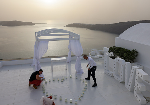 Imerovigli, Santorini, Greece - July 1, 2021: Preparations for a wedding photo session during the sunset in Santorini, Greece
