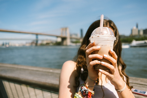 Gen Z girl covers her face with a milkshake in New York City