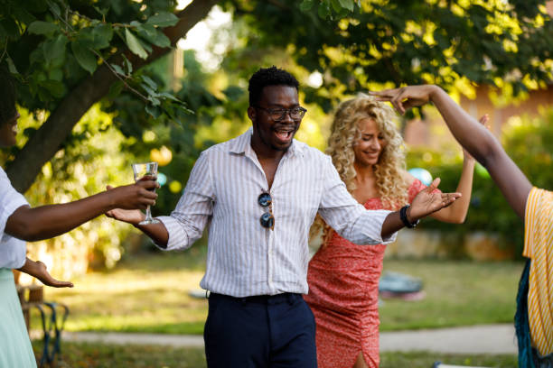 istock Young people enjoying drinks and dancing during a fun garden party 1498511336