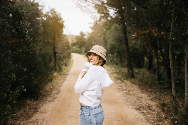 istock Woman wearing a hat walking on a path in a forest 1498516768