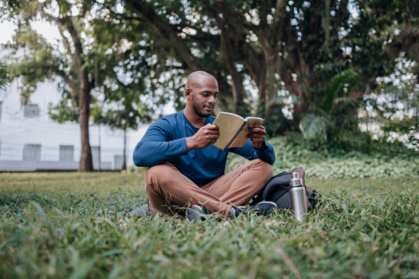 On the lawn in the city park reading a book