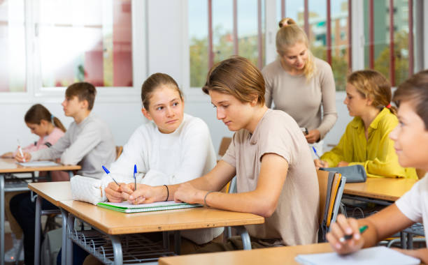istock Group of school kids and teacher during lesson 1498521390