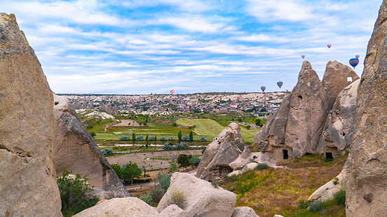 Cappadocia Turkey. Hot air balloons flying over fairy chimneys at sunrise in Cappadocia. Travel to Turkey. Touristic landmarks of Turkiye. Selective focus included