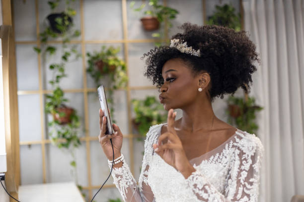 Black woman in wedding dress using mobile phone