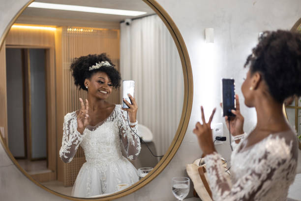istock Black woman in wedding dress using mobile phone 1498530937