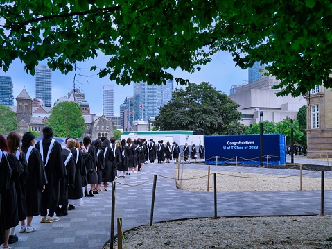 Toronto, Canada - June 13, 2023:   A procession of graduating university students in formal academic gowns go in to receive their diplomas