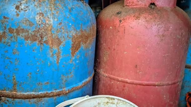 istock Old rusty blue and red gas cylinders in storage 1498539975